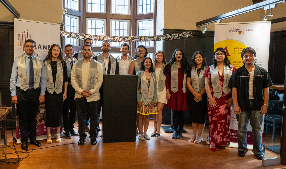 Recent graduates and award recipients from the Latin American Network at McMaster University standing with their ceremonial stoles on stage.